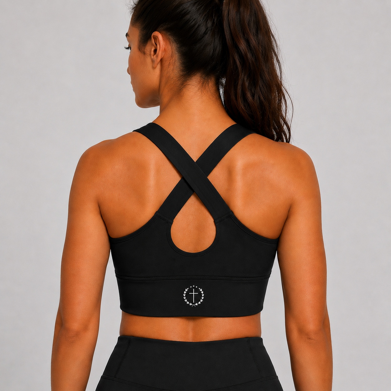 Black sports bra back view with crisscross straps and centered circular logo band